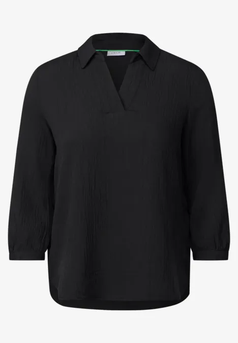 Schwarze Bluse mit V-Ausschnitt und langen Ärmeln.